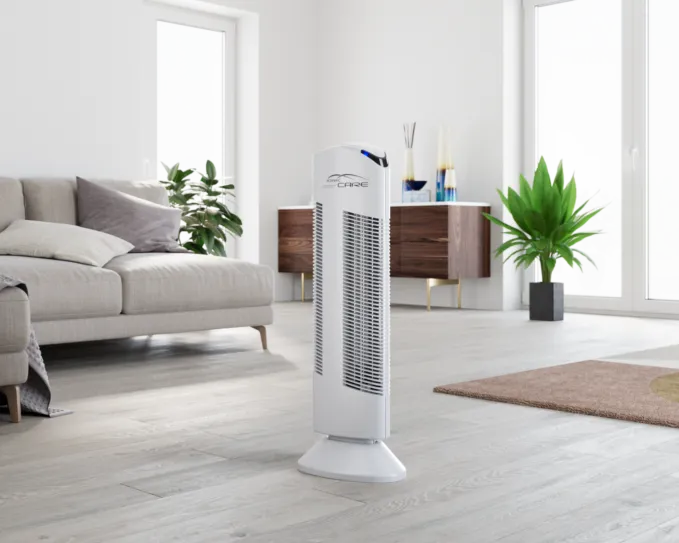 Čistička vzduchu Ionic-CARE bílá v obývacím pokoji s pohovkou v pozadí květiny