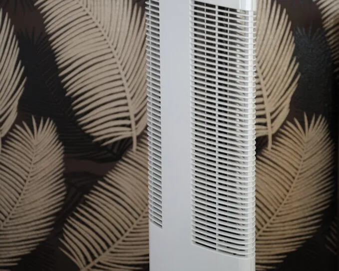 Čistička vzduchu Ionic-CARE v interiéru s tapetou s dekorem peříček, barva perleťově bílá