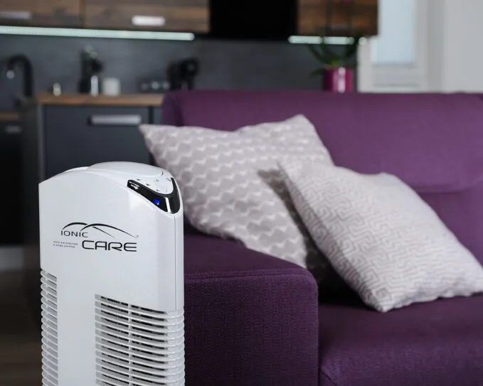 Čistička vzduchu Ionic-CARE v detailu u fialové sedačky, barva perleťově bílá