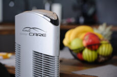 Čistička vzduchu Ionic-CARE v detailu, v pozadí mísa s ovocem, barva stříbrná