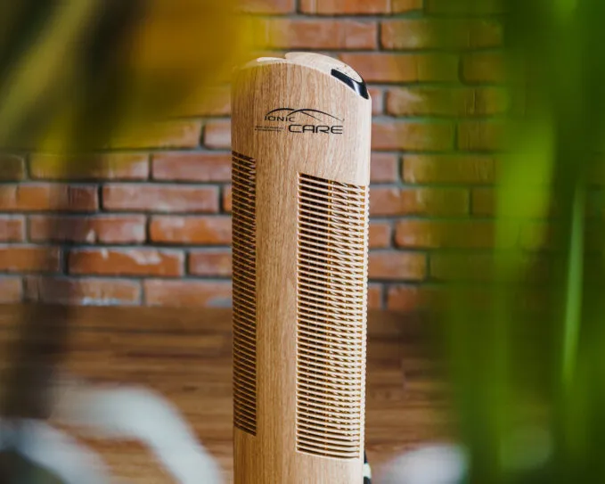 Čistička vzduchu Ionic-CARE v interiéru před cihlovou zdí, dekor dřevo dub