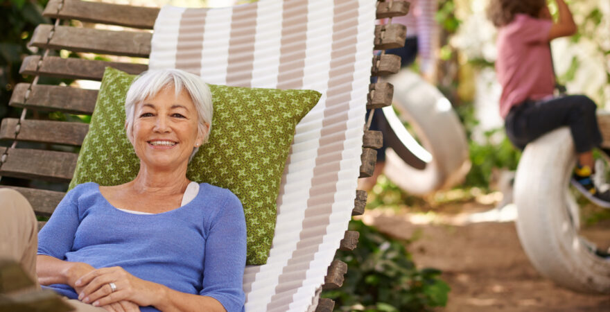 Seniorka relaxující v houpací síti na zahradě
