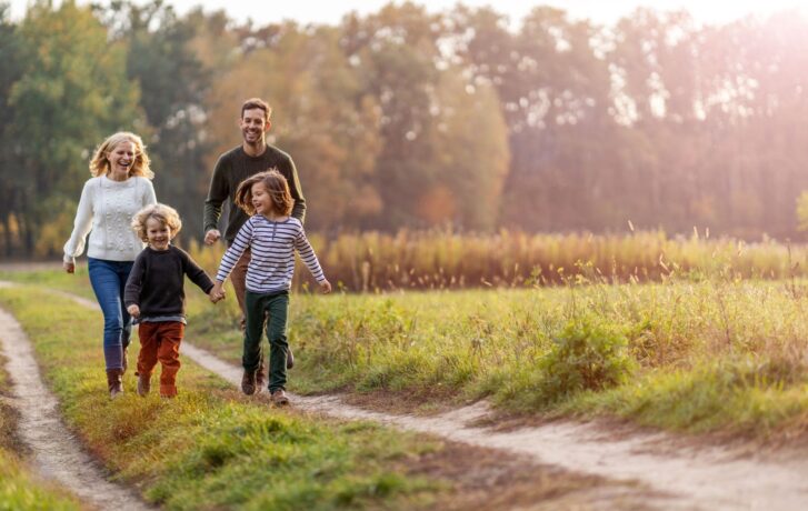 Šťastná rodina s dětmi na ozdravující procházce.